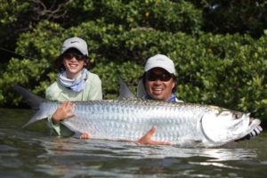 Angler holding tarpon caught on fly fishing trip in Belize